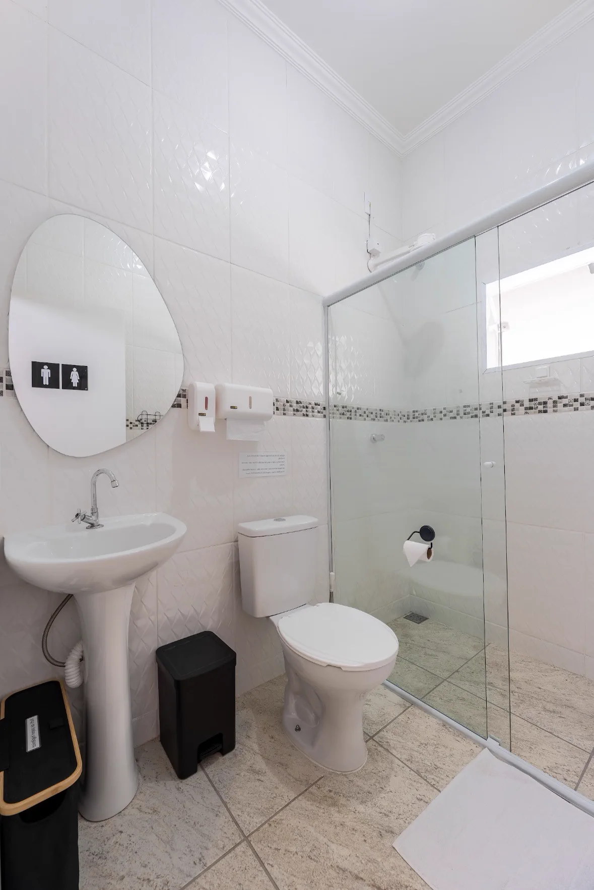 Banheiro com box de vidro e louças brancas