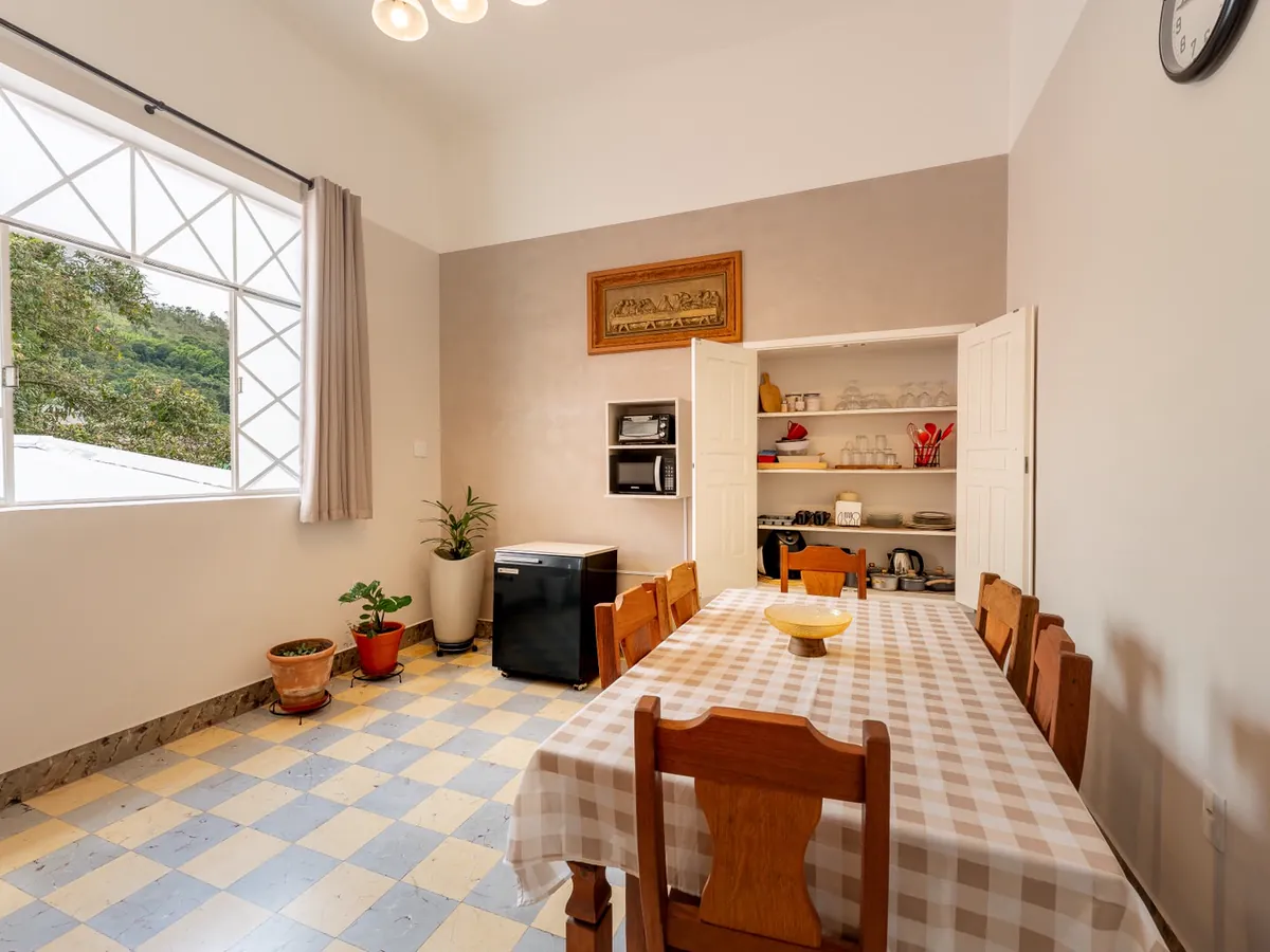 Sala de jantar com mesa grande e armário de louças aberto