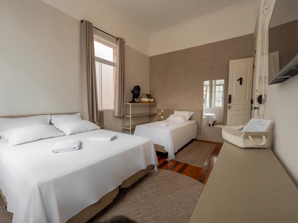 Quarto com cama de casal e cama de solteiro, junto à porta de número 1
