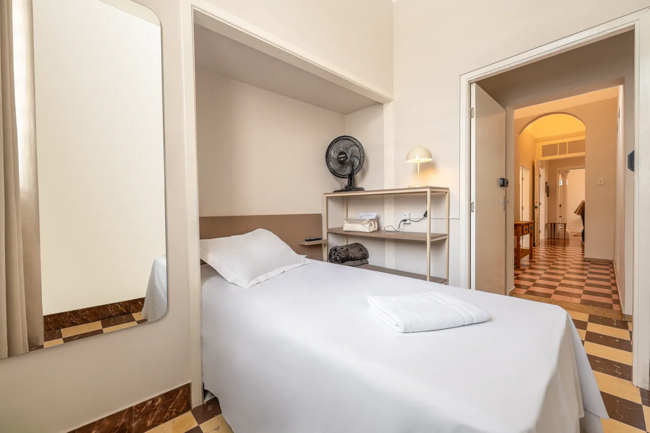 Quarto com espelho e acesso ao corredor