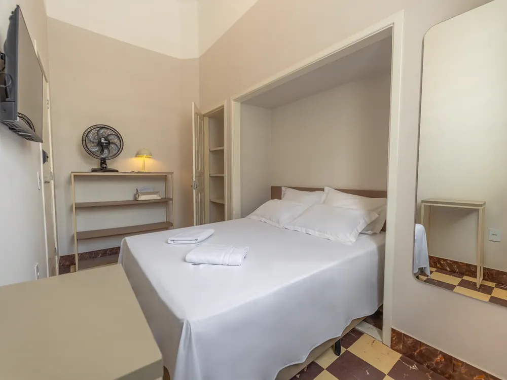 Quarto de casal em nicho, com espelho e piso xadrez do casarão